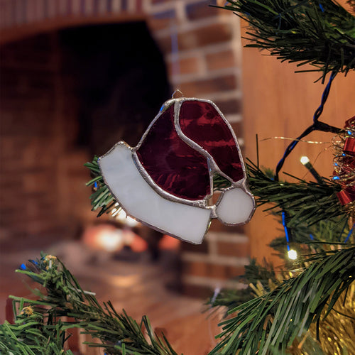 Bonnet de Père Noël en vitrail dans un sapin de Noël