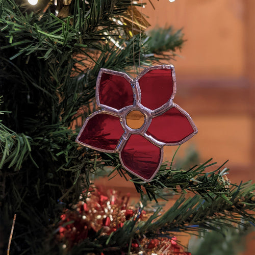 Fleur de Noël en vitrail dans un sapin de Noël